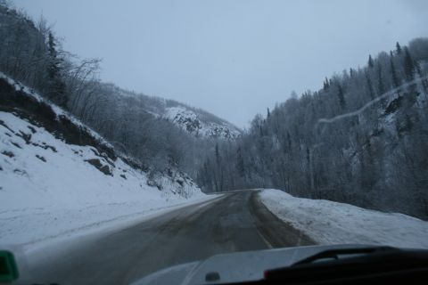 2003 Jeep TJ - Driving through a snow-covered mountain landscape on a winding road.