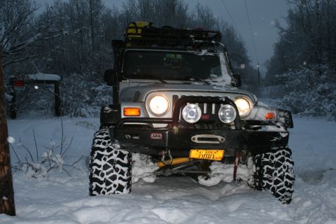 2003 Jeep TJ - A silver Jeep Wrangler equipped for off-road conditions is parked in deep snow.