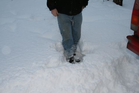 2003 Jeep TJ - A person stands in deep snow next to the rear corner of a red vehicle.