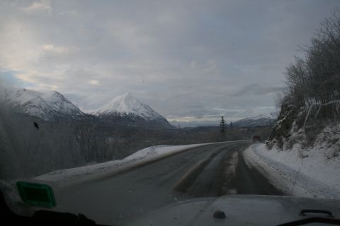 2003 Jeep TJ - View from inside a vehicle driving on a snowy road through a mountain landscape.