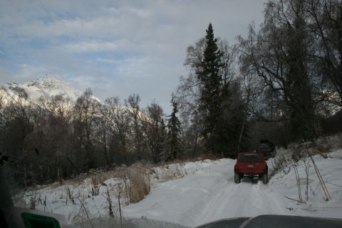 2003 Jeep TJ - Multiple Jeeps navigate a snowy trail with a mountain backdrop.