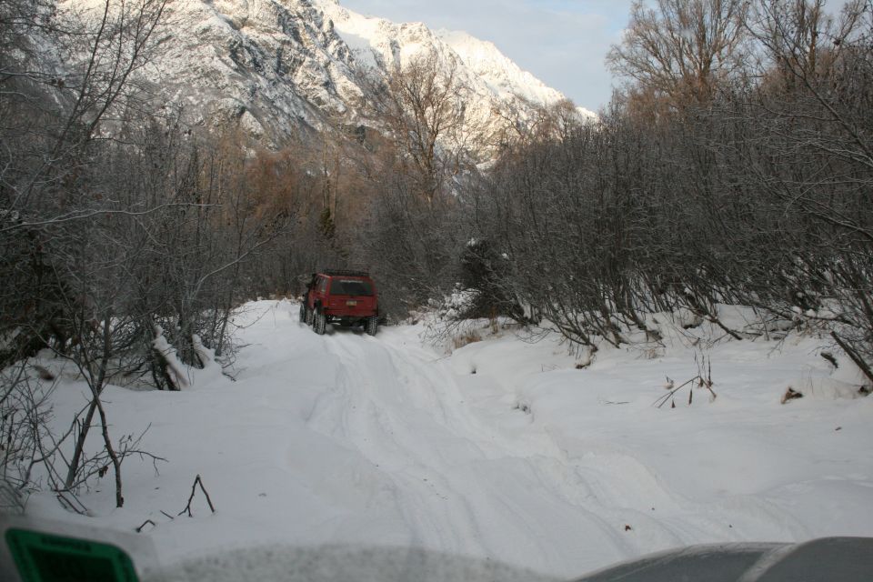 Red SUV driving on a snowy mountain road
