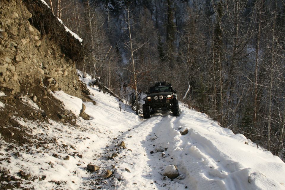 Jeep Wrangler driving up a snowy mountain road