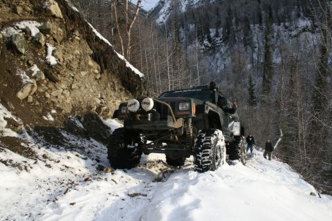 2003 Jeep TJ - A heavily modified Jeep Cherokee XJ navigates a challenging snowy mountain path.