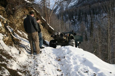 2003 Jeep TJ - A modified 2003 Jeep TJ sits on a snow-covered trail with two people observing the vehicle.