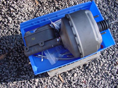 1979 Ford Bronco - Brake booster and master cylinder assembly, likely for an older vehicle, resting in a blue plastic tray.