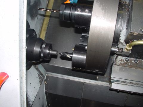 1979 Ford Bronco - A close-up view of a lathe setup, showing two chucks holding drill bits in preparation for a machining operation.