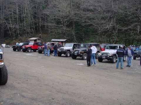 1979 Ford Bronco - A group of Jeeps are gathered in a parking area, with people standing around them.