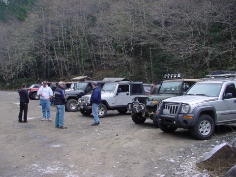 1979 Ford Bronco - A group of off-road vehicles, including a 1997 Ford Bronco, are parked in a wooded area.