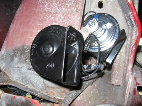 2000 Ford Ranger - Close-up view of two vehicle horns, one black and one silver, with visible wiring.