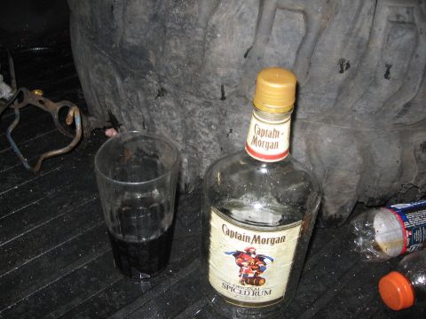 2000 Ford Ranger - A bottle of Captain Morgan rum and a glass of dark liquid sit on a textured surface.