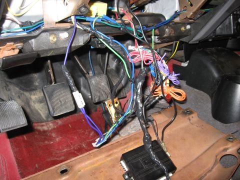 2000 Ford Ranger - The vehicle's interior wiring harness is exposed, with many wires connected to a black control module.