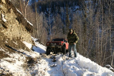 2003 Jeep TJ - Jeep Cherokee XJ navigates a challenging snowy trail with a winch engaged.