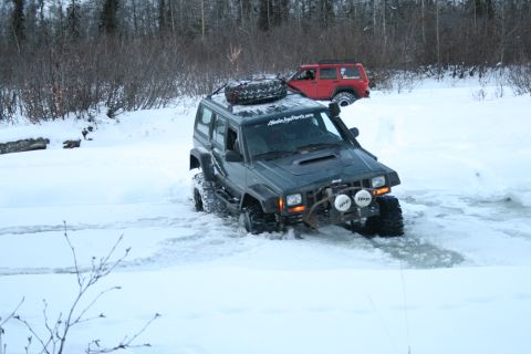 2003 Jeep TJ - Two Jeep Cherokees navigate a snowy, possibly icy, terrain.
