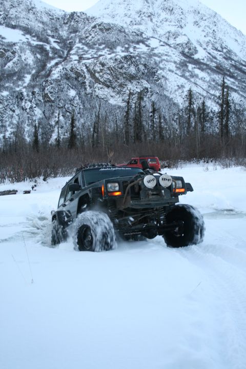 2003 Jeep TJ - Two modified Jeeps navigate a snowy landscape with a mountain in the background.