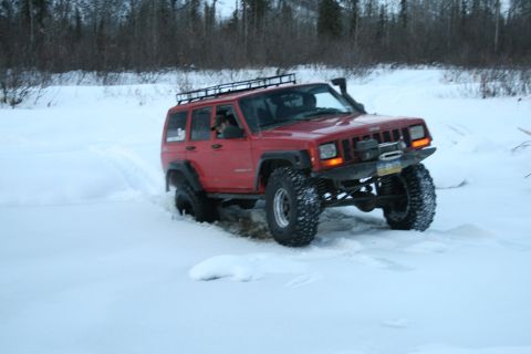2003 Jeep TJ - Jeep Cherokee XJ navigates a snowy landscape, showing off its off-road capabilities.