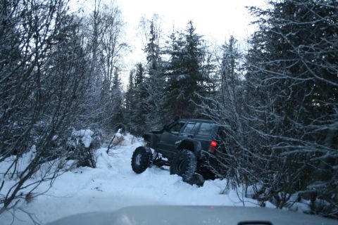 2003 Jeep TJ - Jeep Cherokee XJ navigates a snowy trail with modified suspension and tires.