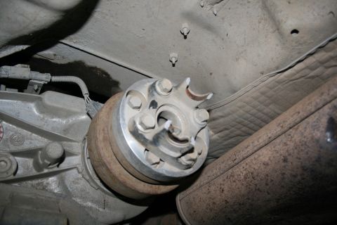 2003 Jeep TJ - Underside view of a damaged driveshaft U-joint and differential assembly on a vehicle.
