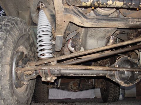 1979 Ford Bronco - Close-up view of the suspension system, highlighting the coil spring and axle components.