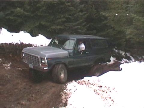 1979 Ford Bronco - Ford Bronco navigates a challenging off-road terrain with mud and snow.