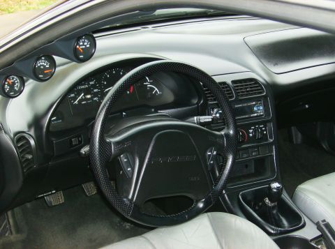 1995 Ford Probe - The interior of a 1995 Ford Probe, a dashboard with multiple gauges and a prominent steering wheel.
