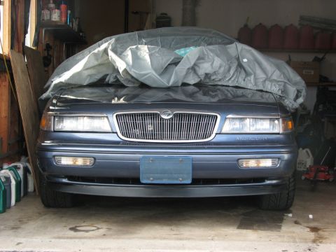 1985 Mercury Grand Marquis - Front view of a 1995 Mercury Grand Marquis parked in a garage, partially covered.
