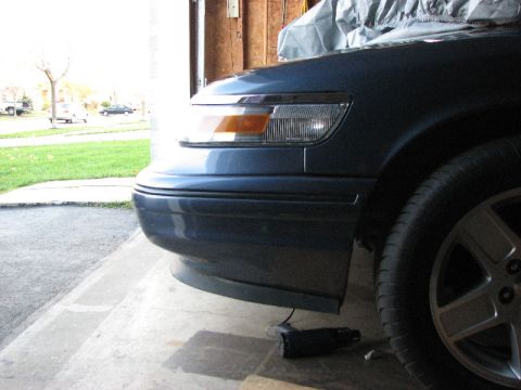 1985 Mercury Grand Marquis - Front corner of a blue car, possibly a 1995 model, with a spoiler visible.