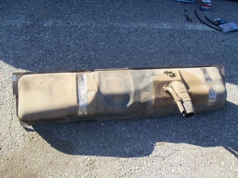 1979 Ford F-100 - A used fuel tank is shown on the ground, with two pipes extending from one end.