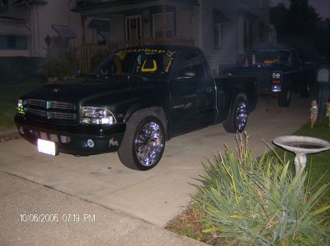 1970 Ford Ranchero - A dark green pickup truck is parked in a driveway next to another vehicle.