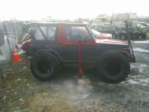 2001 Ford F-350 - Side view of a modified Suzuki Samurai parked outdoors.