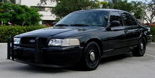 1998 Ford Crown Victoria - A black Ford Crown Victoria Police Interceptor is parked outdoors, showing its front three-quarter view.