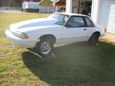 1992 Ford Mustang - This 1992 Ford Mustang features a prominent hood scoop and drag racing tires, suggesting performance modifications.