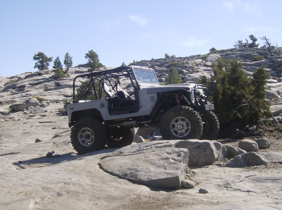 Off-road SUV with roll cage on rocky terrain