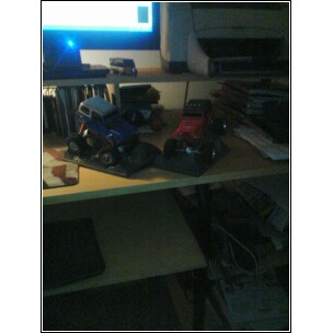 1995 Dodge 1500 - Two toy trucks are displayed on shelves, with a printer and computer monitor in the background.