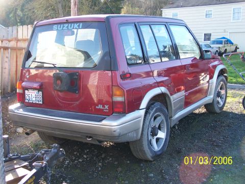 1988 Suzuki Samurai - Rear view of a red 1988 Suzuki Samurai JLX, showing the spare tire mount and license plate.