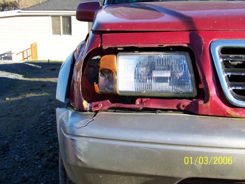 1988 Suzuki Samurai - This red SUV has significant damage to its front end, including a missing headlight and a dented bumper.