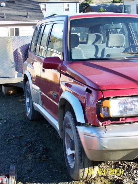 1988 Suzuki Samurai - This red SUV, seen from the front passenger side, is towing a trailer. A watermark indicates the year 2000.
