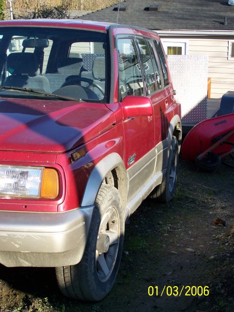 1988 Suzuki Samurai - Red SUV with silver trim parked outdoors. Date stamp shows 01/03/2006.