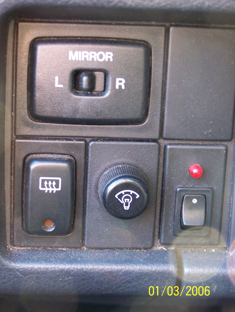 Dashboard controls with mirror selector, rear defroster switch, and dimmer knob