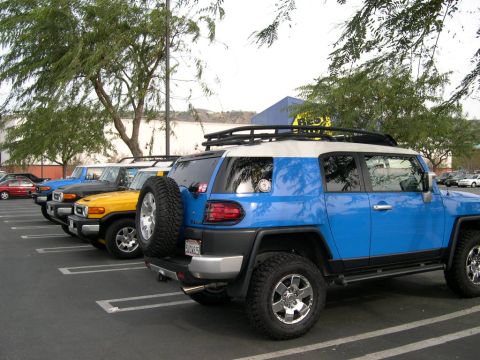2007 Toyota FJ Cruiser - Several Toyota FJ Cruisers are parked in a lot, including a blue one in the foreground.