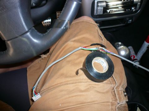 1996 Ford Probe - Someone is working on the wiring inside a car, with electrical tape and loose wires visible.