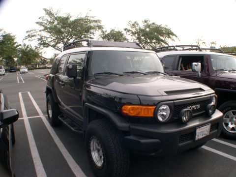2007 Toyota FJ Cruiser - A black 2007 Toyota FJ Cruiser is parked in a lot, with another SUV visible to its right.