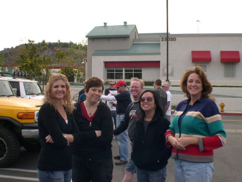 2007 Toyota FJ Cruiser - A group of people stand in front of a yellow 2007 Toyota FJ Cruiser and a building.