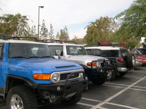 2007 Toyota FJ Cruiser - Multiple Toyota FJ Cruisers are parked in a lot under a cloudy sky.