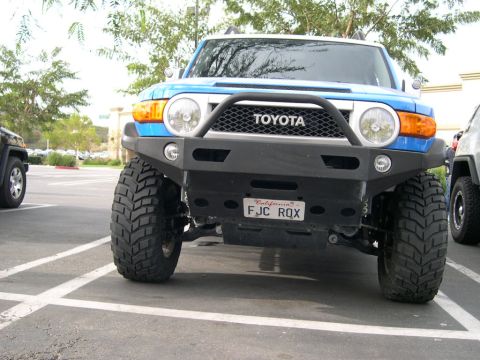 2007 Toyota FJ Cruiser - A blue 2007 Toyota FJ Cruiser is parked in a lot, a prominent aftermarket bumper and tires.