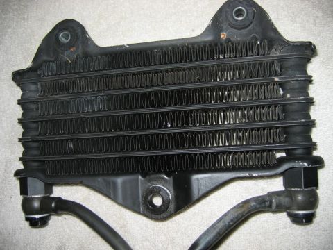 1985 Ford LTD Crown Victoria - This is a black oil cooler with attached hoses and mounting hardware, shown from the front.