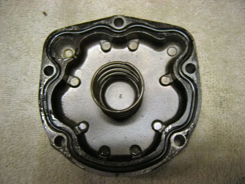1985 Ford LTD Crown Victoria - A disassembled metal component, possibly from a vehicle's engine or transmission, is shown with its internal spring and external seals.