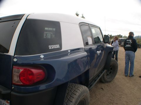 2007 Toyota FJ Cruiser - A blue and white 2007 Toyota FJ Cruiser is parked outdoors with people standing nearby.