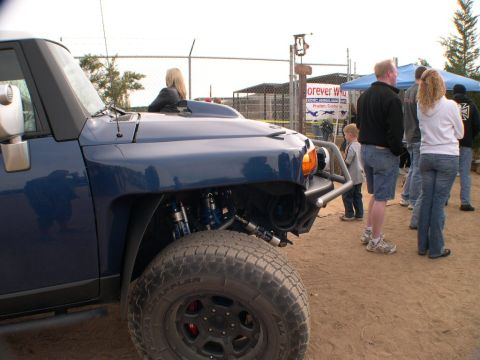 2007 Toyota FJ Cruiser - A blue SUV is shown from the front quarter with aftermarket suspension and bumper, with people in the background.