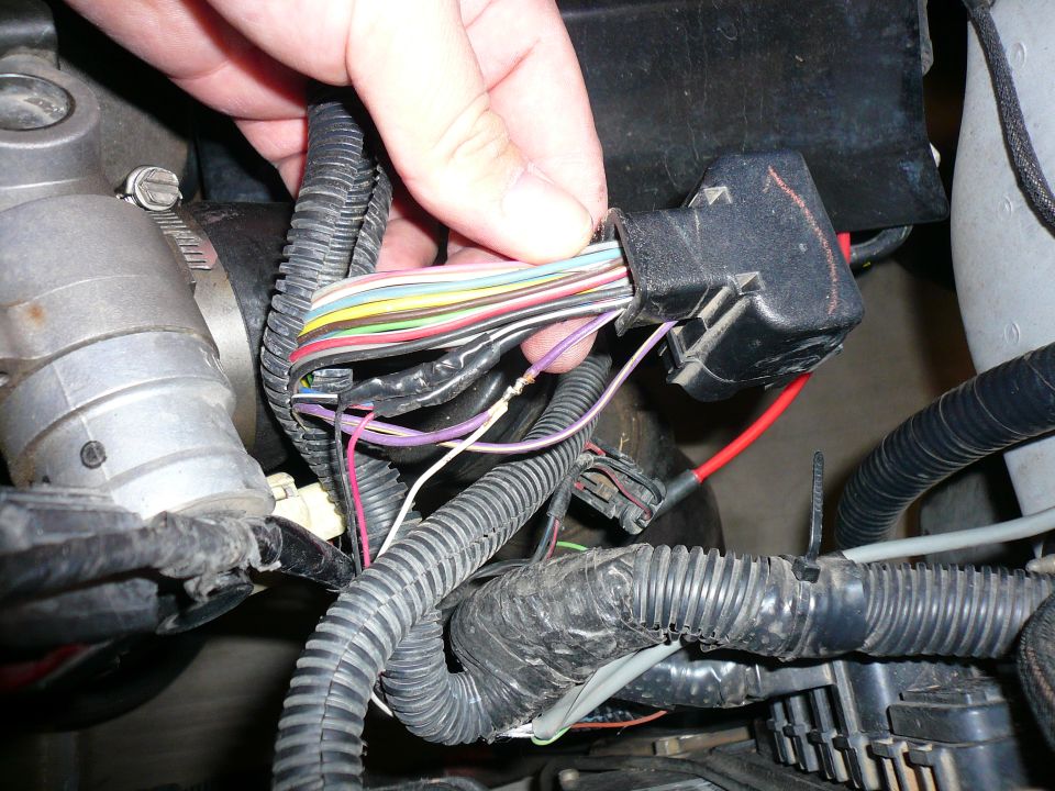 Hand disconnecting a multi-wire electrical connector in an engine bay
